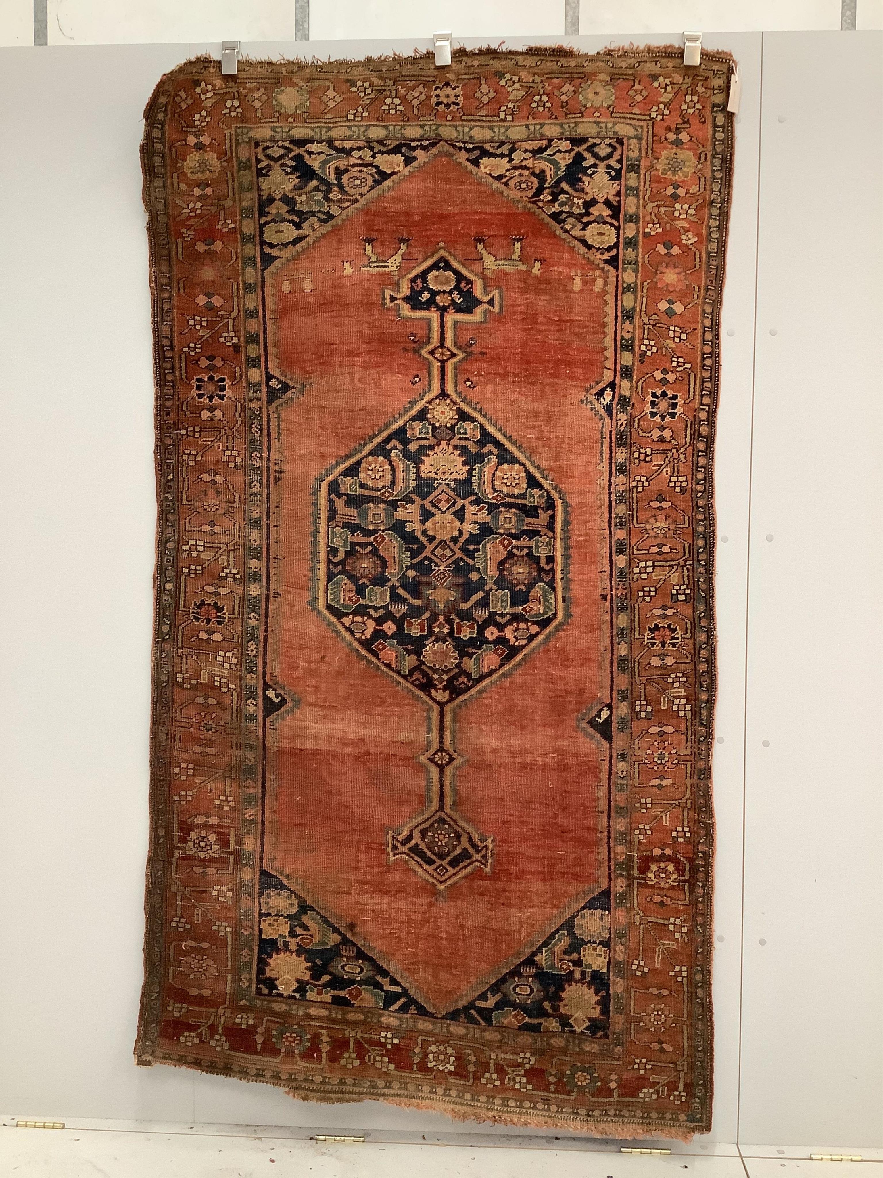 A North West Persian brick red ground rug, 230 x 126cm. Condition - poor